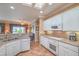 Bright open kitchen with white cabinets, stone countertops and view to the living room at 2319 Hardin Ridge Dr, Henderson, NV 89052