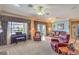 Bright living room featuring plush seating, a piano, and views of the backyard landscape at 2319 Hardin Ridge Dr, Henderson, NV 89052