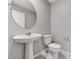 Modern powder room featuring a pedestal sink, oval mirror, and neutral wall paint at 2456 Bagnara Pl, Henderson, NV 89044