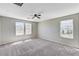 Spacious bedroom with three windows, neutral walls, and carpeted floor at 2456 Bagnara Pl, Henderson, NV 89044