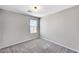 A bright bedroom featuring plush gray carpeting, neutral walls, and a window at 2456 Bagnara Pl, Henderson, NV 89044