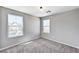 A bright and airy bedroom featuring plush gray carpeting, neutral walls, and two windows at 2456 Bagnara Pl, Henderson, NV 89044