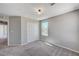 A bright bedroom featuring plush gray carpeting, neutral walls, a window, and a double door closet at 2456 Bagnara Pl, Henderson, NV 89044