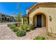 Inviting two-story townhome with an archway entry, desert landscaping and paver sidewalk at 2456 Bagnara Pl, Henderson, NV 89044