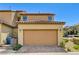 Two-car garage of a two-story townhome with neutral stucco and minimal landscaping at 2456 Bagnara Pl, Henderson, NV 89044