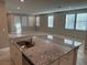 Open concept kitchen flowing into the living space with island and granite countertops at 2456 Bagnara Pl, Henderson, NV 89044