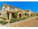 Street view of new townhomes with arched entryways, tile roofs and desert landscaping at 2456 Bagnara Pl, Henderson, NV 89044