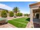 Beautiful backyard featuring artificial turf, gravel landscaping, mature trees and a covered patio at 2913 Hawksdale Dr, Las Vegas, NV 89134