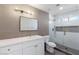 Modern bathroom featuring a glass shower, gray tile, and a large vanity with gold hardware at 2913 Hawksdale Dr, Las Vegas, NV 89134