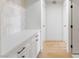 Long hallway featuring hardwood floors, white walls, and a white countertop with plenty of storage at 2913 Hawksdale Dr, Las Vegas, NV 89134