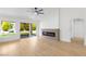 Bright living room with hardwood floors, fireplace, ceiling fan, and sliding glass doors to the backyard at 2913 Hawksdale Dr, Las Vegas, NV 89134