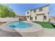 Backyard featuring a kidney-shaped pool, artificial turf, and two-story house at 3743 Prairie Orchid Ave, North Las Vegas, NV 89081
