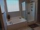 Bathroom with a tub, shower, and window with blinds at 3862 E Summit Ave, Pahrump, NV 89061