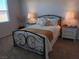 Cozy bedroom featuring a metal-frame bed, carpet, and bedside tables with lamps at 3862 E Summit Ave, Pahrump, NV 89061