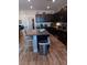 Modern kitchen featuring dark cabinets, granite countertops, a center island, and stainless steel appliances at 3862 E Summit Ave, Pahrump, NV 89061