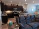 Open-concept living space featuring a modern kitchen with dark cabinetry and a comfortable living area at 3862 E Summit Ave, Pahrump, NV 89061