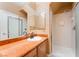 Bathroom featuring marble counters, double mirrors, vanity lighting and a step-in shower with glass door at 395 Suzanne Peak Ct, Henderson, NV 89012