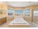 Bright bathroom featuring a large tub, cabinets, and big windows providing natural light and neighborhood views at 395 Suzanne Peak Ct, Henderson, NV 89012