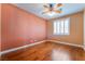 Comfortable bedroom featuring hardwood floors, ceiling fan, and a window with shutter blinds at 395 Suzanne Peak Ct, Henderson, NV 89012