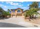 Beautiful two-story home with a three-car garage, front yard desert landscaping, and a welcoming facade at 395 Suzanne Peak Ct, Henderson, NV 89012