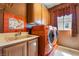 Laundry room featuring a sink, cabinets, a window with curtains, and a washer and dryer set at 395 Suzanne Peak Ct, Henderson, NV 89012