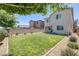 Expansive backyard featuring a lush green lawn, complemented by a brick wall and neatly trimmed shrubs at 4050 Midnight Crest Ave, North Las Vegas, NV 89031