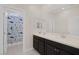 Bright bathroom featuring a double sink vanity with sleek, dark cabinetry and a fun shark-themed shower curtain at 4050 Midnight Crest Ave, North Las Vegas, NV 89031