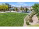 A view of a community park featuring a playground, picnic tables and a large grassy field at 4050 Midnight Crest Ave, North Las Vegas, NV 89031