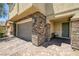 Beautiful home entrance featuring stone accents, a two-car garage, and a cozy porch at 4050 Midnight Crest Ave, North Las Vegas, NV 89031