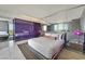 Modern bedroom featuring a large bed, mirrored wall, and purple accents; stylish and comfortable space at 4381 W Flamingo Rd # 1101, Las Vegas, NV 89103