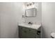 Chic powder room featuring a green vanity, white countertop, and sleek black fixtures at 4607 El Camino Cabos Dr, Las Vegas, NV 89147