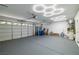 Organized garage space featuring epoxy flooring, bright lighting, and ample storage at 4607 El Camino Cabos Dr, Las Vegas, NV 89147