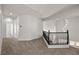 Upstairs hallway with carpet and decorative black railing overlooking the entryway at 4607 El Camino Cabos Dr, Las Vegas, NV 89147