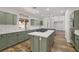 Bright, open kitchen with an island cooktop, ample counter space, and green cabinets at 4607 El Camino Cabos Dr, Las Vegas, NV 89147