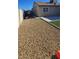 A serene backyard featuring stone, artificial grass, a concrete walkway, and partial views of the home at 4690 E California Ave, Las Vegas, NV 89104