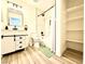 Bright bathroom with wood-look floors, a vanity, a tub-shower with tile surround and a storage space at 4881 E Imperial Ave, Las Vegas, NV 89104