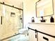 Modern bathroom showcasing a glass-enclosed shower, stylish vanity with dark fixtures, and a sliding barn door at 4881 E Imperial Ave, Las Vegas, NV 89104