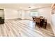 Spacious dining area featuring modern wood-look flooring, a large window, and a simple, elegant table set at 4881 E Imperial Ave, Las Vegas, NV 89104
