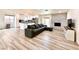 Open-concept living area featuring wood flooring, a brick fireplace, and an adjacent modern kitchen at 4881 E Imperial Ave, Las Vegas, NV 89104