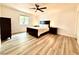 Main bedroom featuring modern wood-look floors, a ceiling fan, neutral walls, and plenty of natural light at 4881 E Imperial Ave, Las Vegas, NV 89104