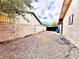 Side yard with rock landscaping, fenced perimeter, gate, and exterior entrance to the home at 4881 E Imperial Ave, Las Vegas, NV 89104