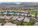 Aerial view of a residential neighborhood with a golf course, pond, and mountain views at 5068 Rivedro St, Las Vegas, NV 89135