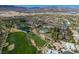 Stunning aerial view of a beautiful community with lush golf course, pools, and tennis courts with a mountain backdrop at 5068 Rivedro St, Las Vegas, NV 89135