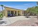 Open backyard featuring a spacious patio, lush greenery, and desert landscaping at 5068 Rivedro St, Las Vegas, NV 89135