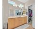 A bright bathroom featuring double sinks, a large mirror, and a walk-in closet at 5068 Rivedro St, Las Vegas, NV 89135