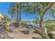 Outdoor patio area featuring dining sets overlooking a serene lake surrounded by palm trees at 5068 Rivedro St, Las Vegas, NV 89135