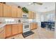 Well-lit kitchen with wooden cabinets, white appliances, and a cozy breakfast nook at 5068 Rivedro St, Las Vegas, NV 89135