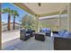 Covered patio with cozy seating, offering a relaxing outdoor space with a view of palm trees at 5068 Rivedro St, Las Vegas, NV 89135