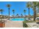 Community pool surrounded by palm trees, lounge chairs, and shaded areas at 5068 Rivedro St, Las Vegas, NV 89135