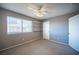 Bedroom with neutral carpet, light gray walls, a ceiling fan, and a window with shelving at 5241 Janfred Ct # 18, Las Vegas, NV 89103
